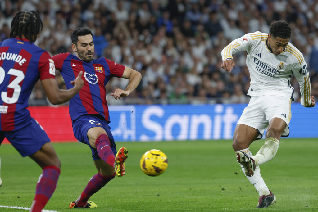 El centrocampista británico del Real Madrid Jude Bellingham (d) disputa un balón con el centrocampista alemán del FC Barcelona Ilkay Gündogan (2i) durante el partido de la jornada 32 de LaLiga entre Real Madrid y FC Barcelona.