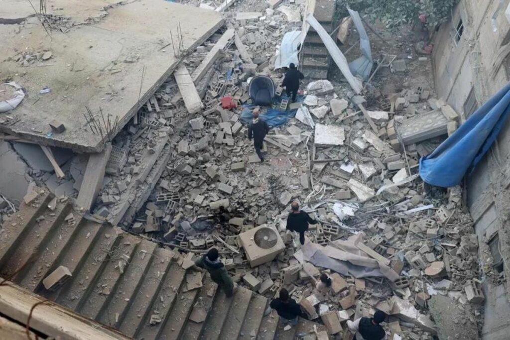 Supervivientes caminan entre los escombros tras un bombardeo de Israel en el campo de refugiados de Yenín.