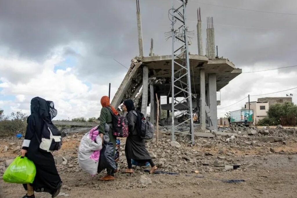 Mujeres palestinas caminan con sus pertenencias después de la orden de evacuación emitida por el ejército israelí, en Rafah. Foto: Haitham Imad/EFE