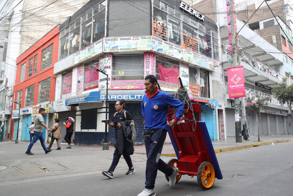 Personas caminan junto a locales comerciales en la ciudad de Lima (Perú).
