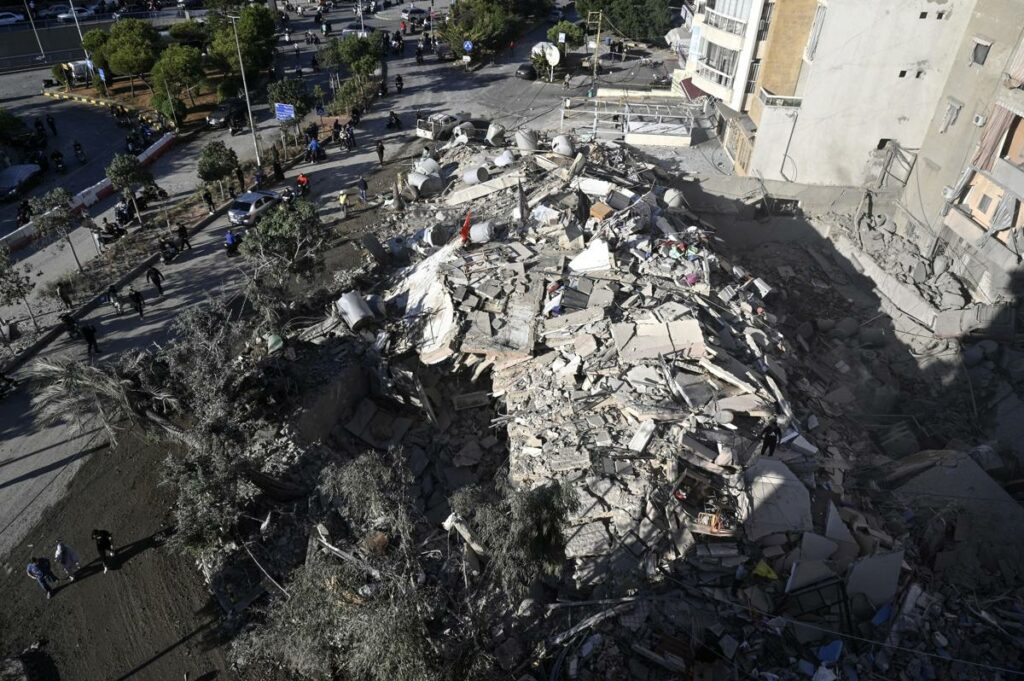 La gente se reúne en el lugar de una estructura dañada tras un ataque aéreo israelí en el distrito de Dahieh, al sur de Beirut, Líbano, el 22 de octubre de 2024.