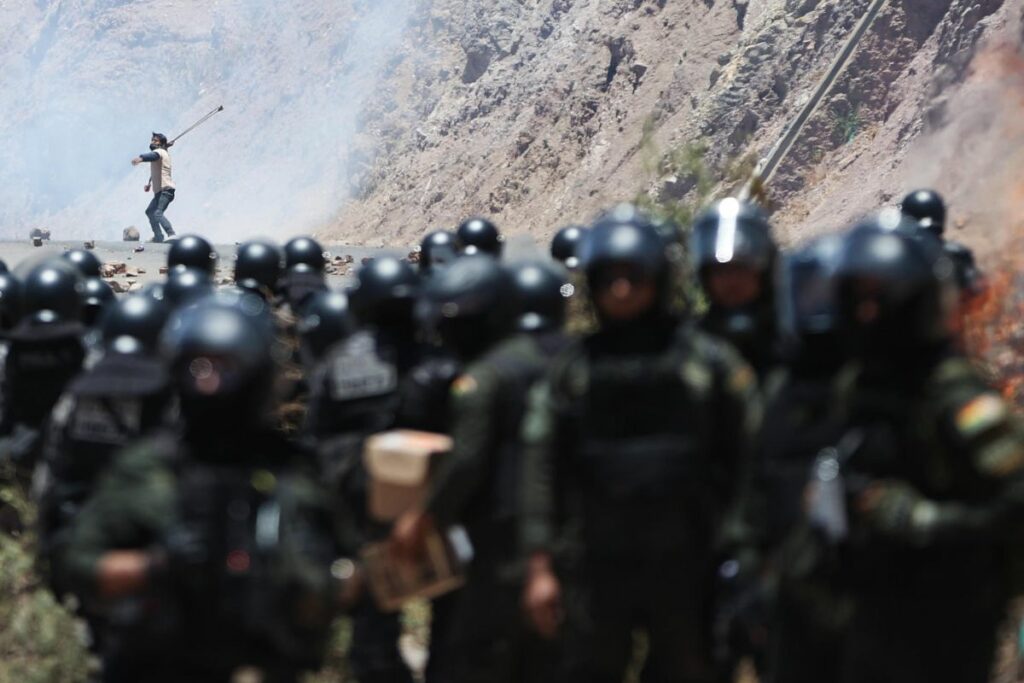 Un hombre se enfrenta con miembros de la Policía Militar Boliviana durante un bloqueo por simpatizantes del expresidente de Bolivia, Evo Morales, en Parotani (Bolivia). EFE