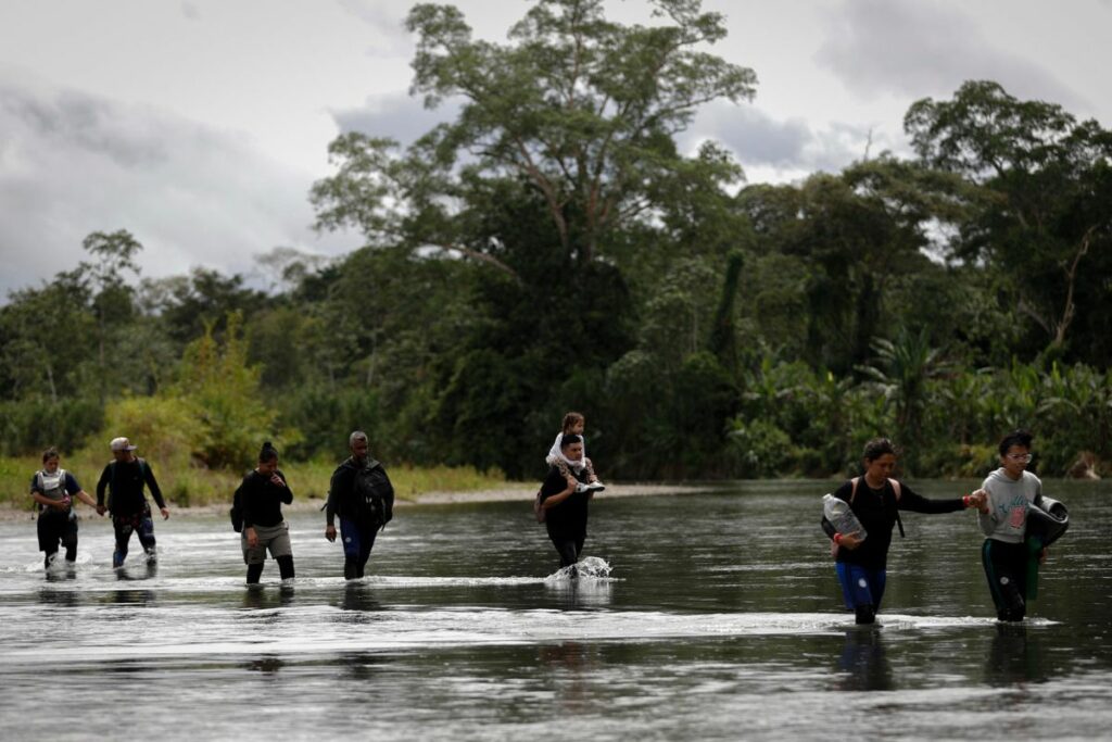Migrantes cruzan el río Tuquesa luego de atravesar la selva del Darién, este jueves en el Darien (Panamá). EFE