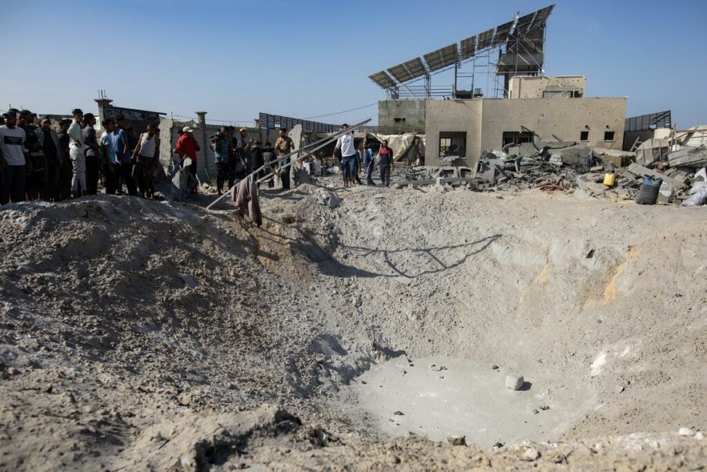 Palestinos inspeccionan el cráter de un proyectil tras el bombardeo israelí en un campamento que alberga a desplazados internos en Khan Younis, sur de la Franja de Gaza.