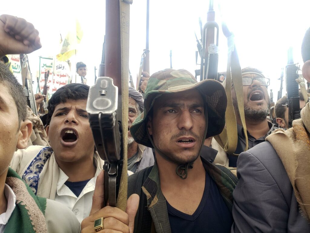 Partidarios hutíes corean consignas y empuñan armas durante una protesta.