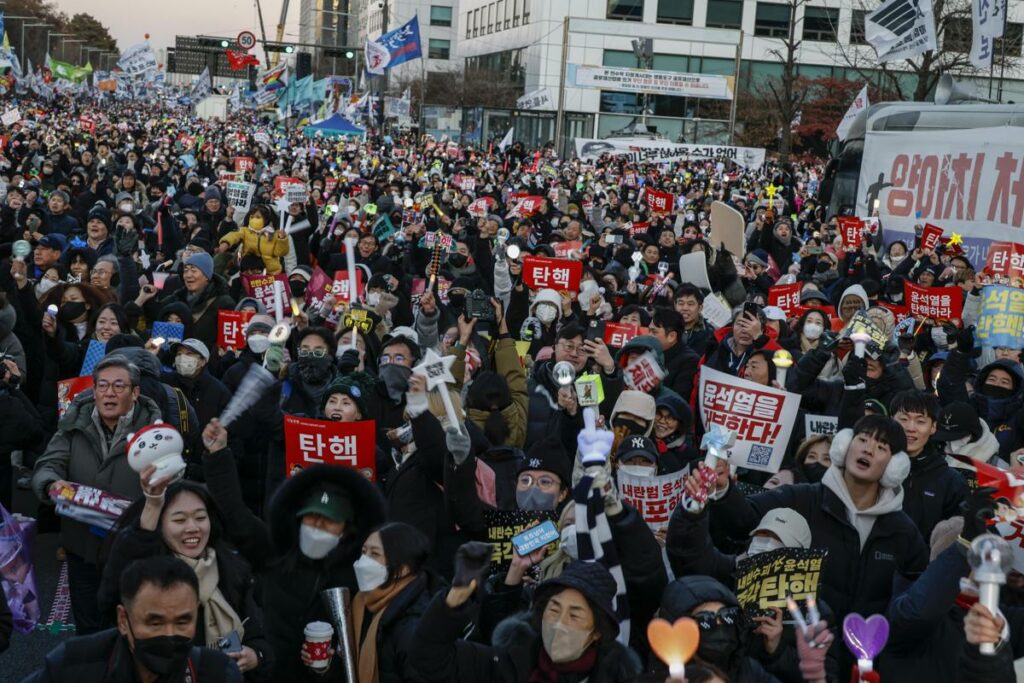 Los manifestantes celebran tras la aprobación de una moción de juicio político contra el presidente Yoon Suk Yeol.