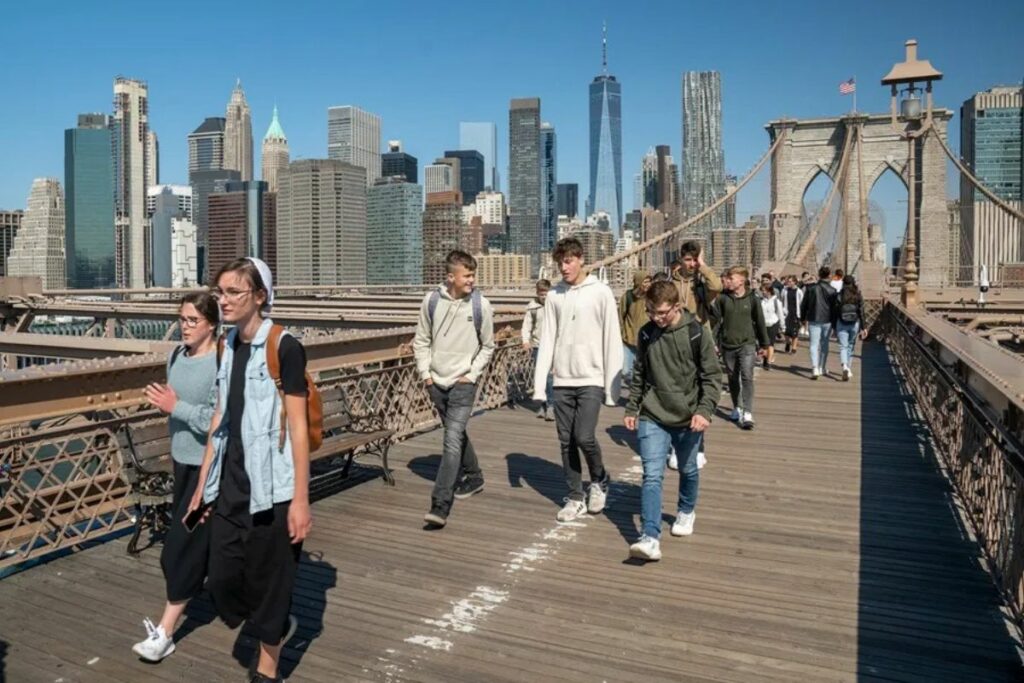 Turistas cruzan el icónico puente de Brooklyn, que une los distritos de Manhattan y Brooklyn, en la ciudad de Nueva York (EEUU).