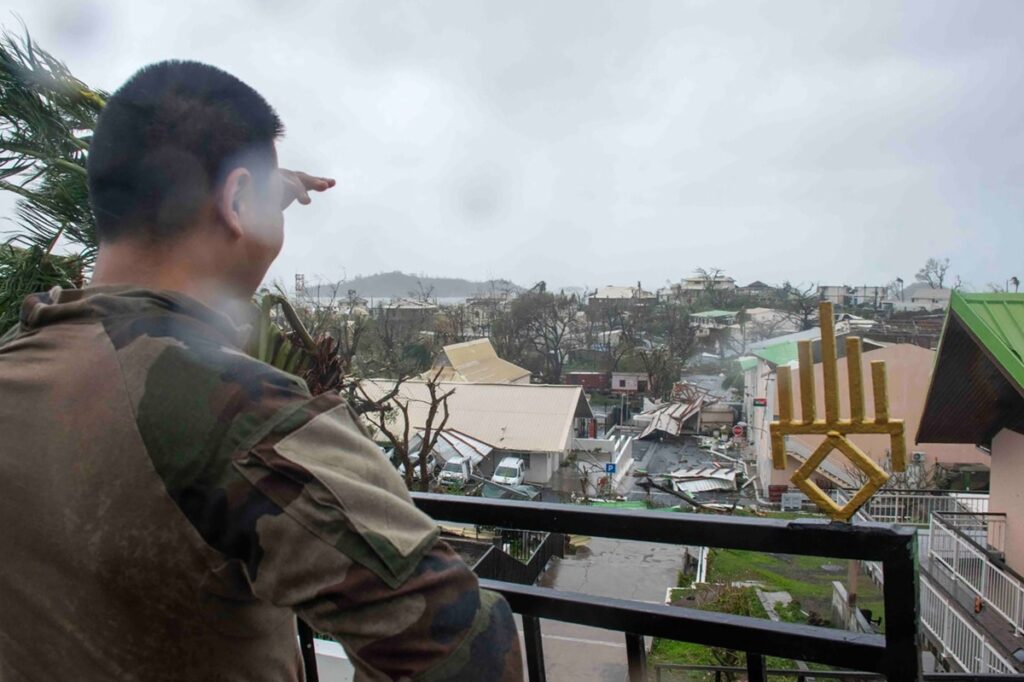Una fotografía proporcionada por el ejército francés el 15 de diciembre de 2024 muestra a un soldado en una zona con vistas a los daños en el territorio francés de ultramar de Mayotte.
