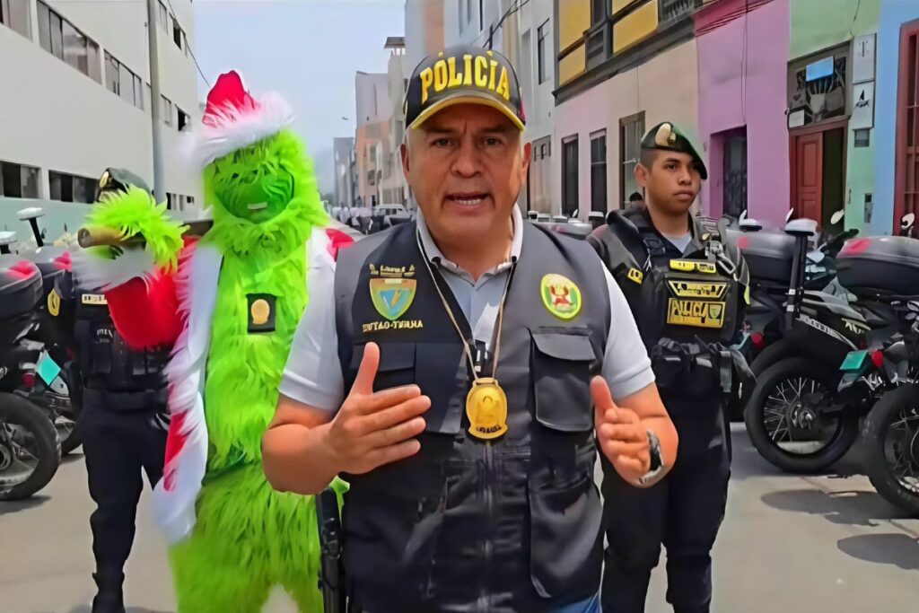 Captura de pantalla de un video cedido por la Policía Nacional del Perú (PNP) de un policía (i) disfrazado como el personaje navideño del 'Grinch'.
