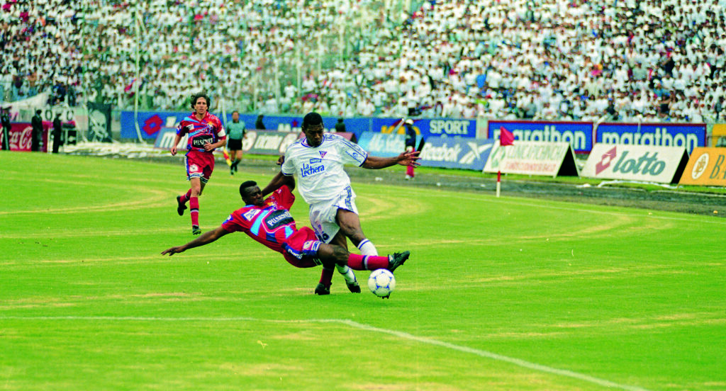 Eduardo 'Tanque' Hurtado (blanco) de Liga de Quito disputa un balón ante sus rivales de El Nacional en la final de 1999.