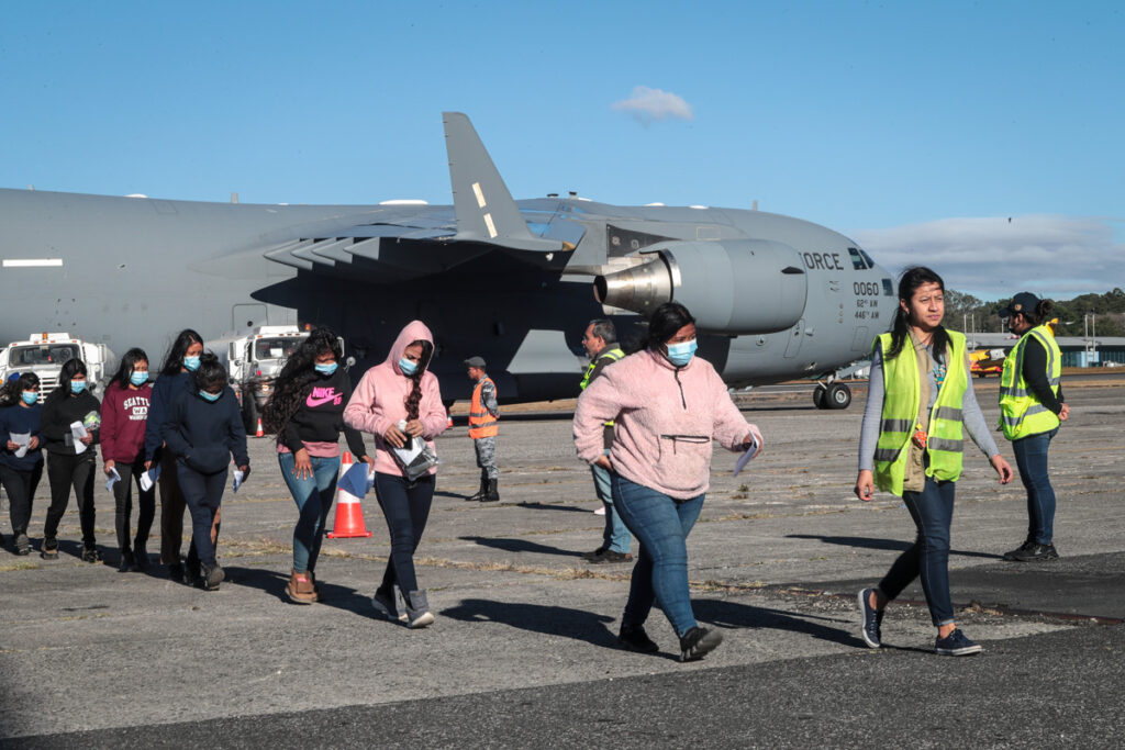 Migrantes guatemaltecos deportados caminan por la pista de la Base Aérea de Guatemala.