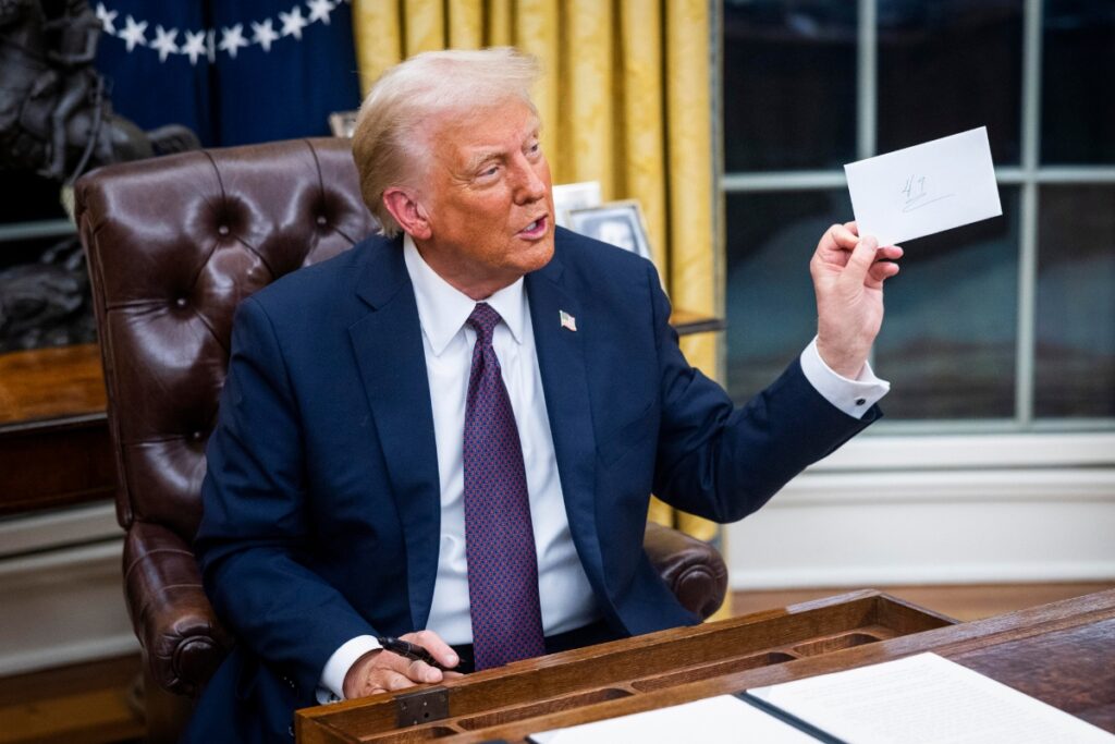 El presidente de los Estados Unidos, Donald Trump, observa una carta del expresidente Joe Biden que dejó en el cajón del escritorio Resolute.