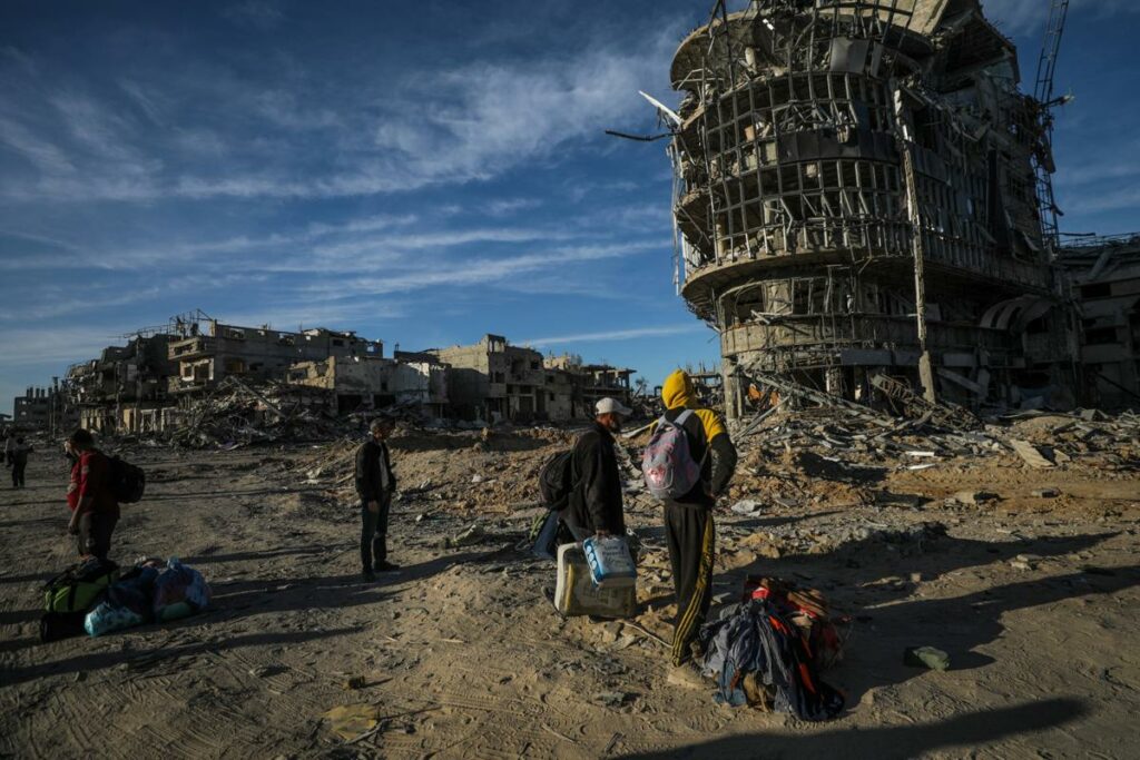 Palestinos desplazados internos caminan por una calle entre los escombros de edificios destruidos en medio de un alto el fuego entre Israel y Hamás, en Rafah, sur de la Franja de Gaza.
