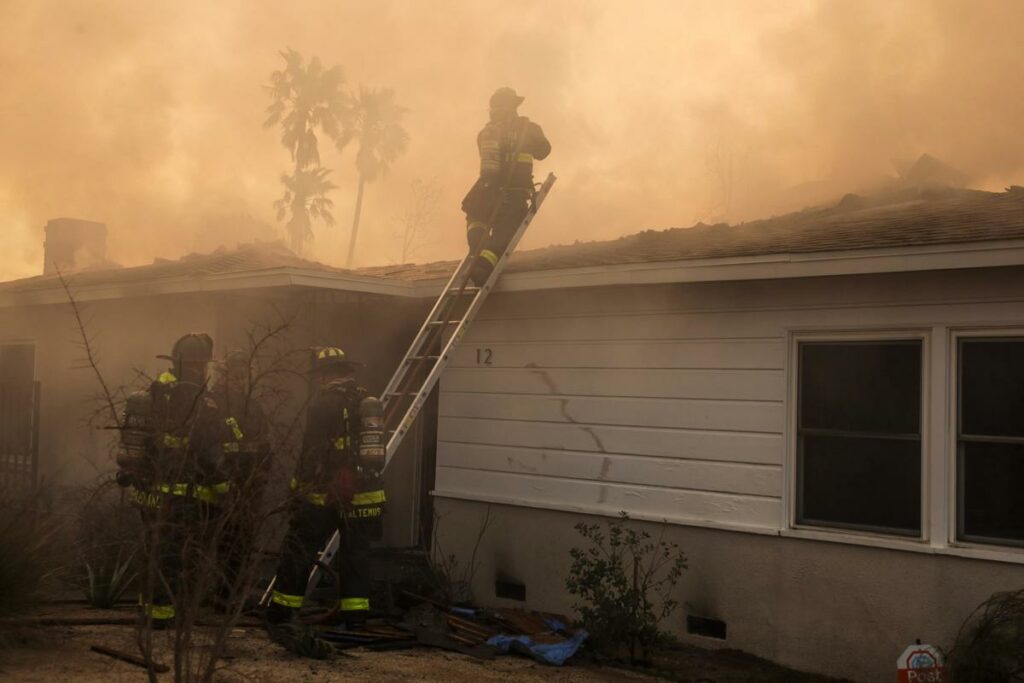 Bomberos combaten un incendio en una casa causado por el incendio forestal Eaton en Altadena, California, EE.UU..