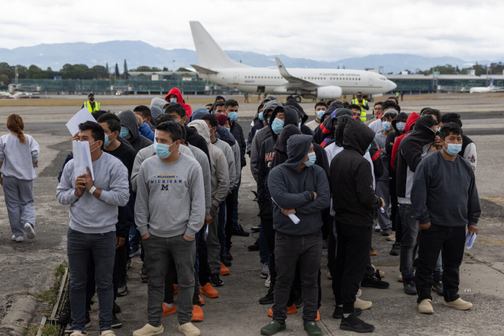 Fotografía del 2 de enero de 2025 de un grupo de guatemaltecos esperando en la base de la Fuerza Aérea de Guatemala, durante el primer vuelo de deportados enviado por Estados Unidos desde El Paso, Texas, en Ciudad de Guatemala.