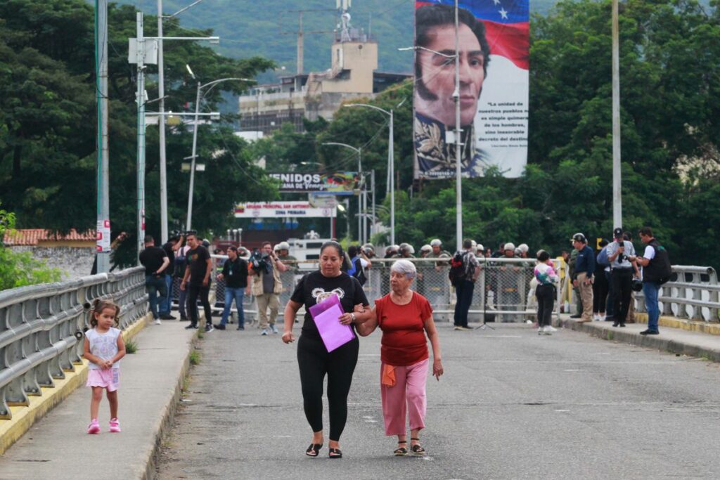 Personas caminan en el Puente Simón Bolívar, que une a Villa del Rosario (Colombia) con San Antonio del Táchira (Venezuela), bloqueado por integrantes de la Guardia Nacional Bolivariana (GNB) el viernes 10 de enero, en Villa del Rosario (Colombia).