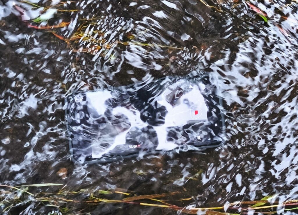 Redmi Note 14 Pro 5G sumergido en un arroyo.