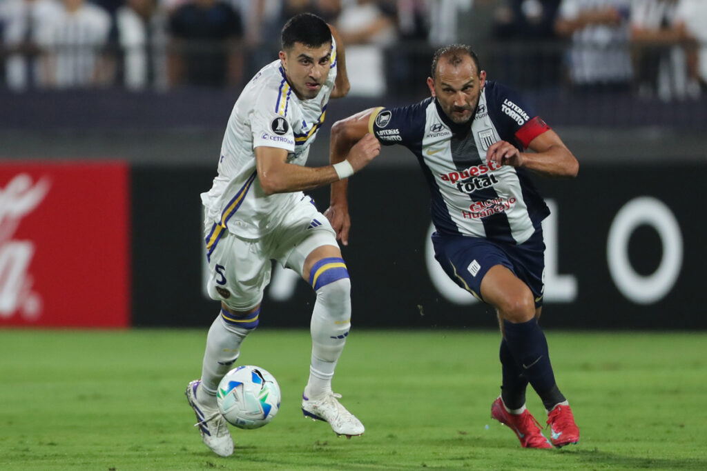 Hernán Barcos (der.) de Alianza Lima disputa un balón contra un rival de Boca Juniors en la Copa Libertadores de América.