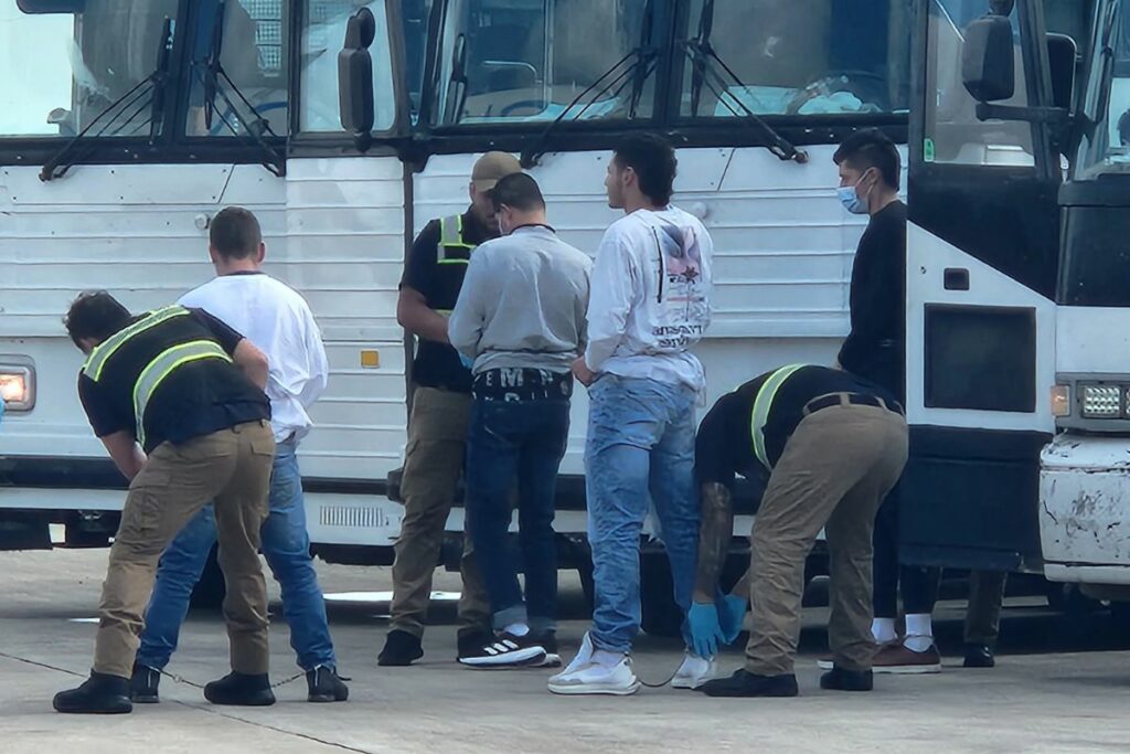 Oficiales de migración requisan a migrantes antes de ser deportados, en el Aeropuerto de Harlingen, Texas (Estados Unidos). EFE