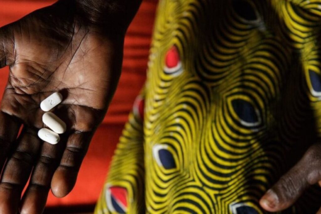 En Costa de Marfil, una mujer que vive con VIH sostiene tres pastillas que toma diariamente como parte de la terapia antirretroviral. Foto: IPS