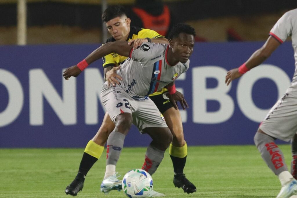 Jawer Guisamano (gris) protege un balón contra Bryan Oyola de Barcelona SC.