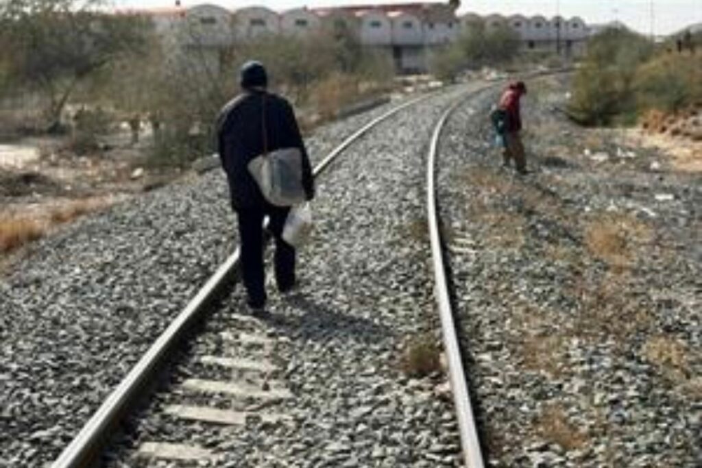 Dos migrantes caminan por unas vías de tren este lunes en la ciudad de Altar en Sonora (México).
