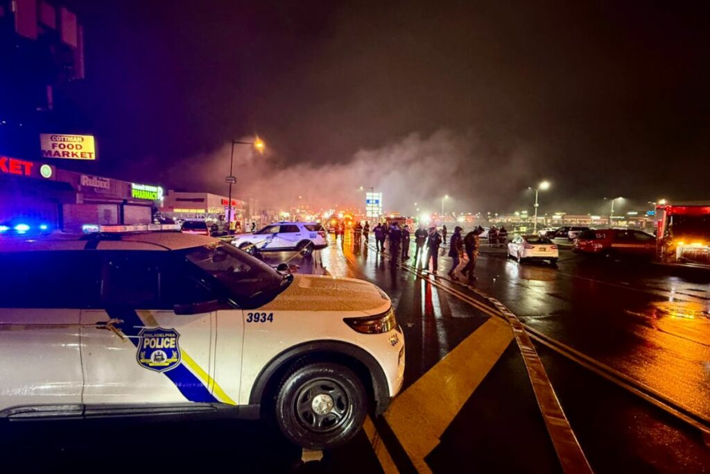 Agentes de policía en el lugar donde un avión se estrelló en la noche del viernes en Filadelfia, Estados Unidos.