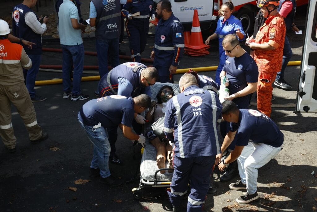 Un persona es auxiliada este miércoles, en Río de Janeiro (Brasil). Un gran incendio se desató en una fábrica textil especializada en disfraces para el carnaval.