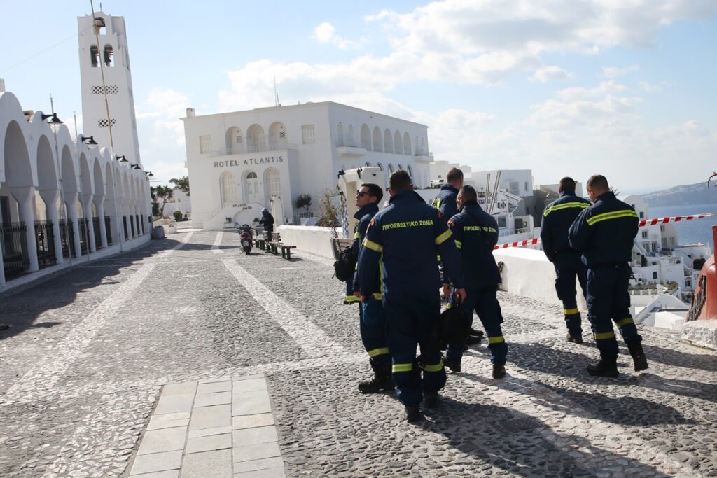 Los bomberos caminan en el pueblo casi evacuado de Fira en Santorini, Grecia.