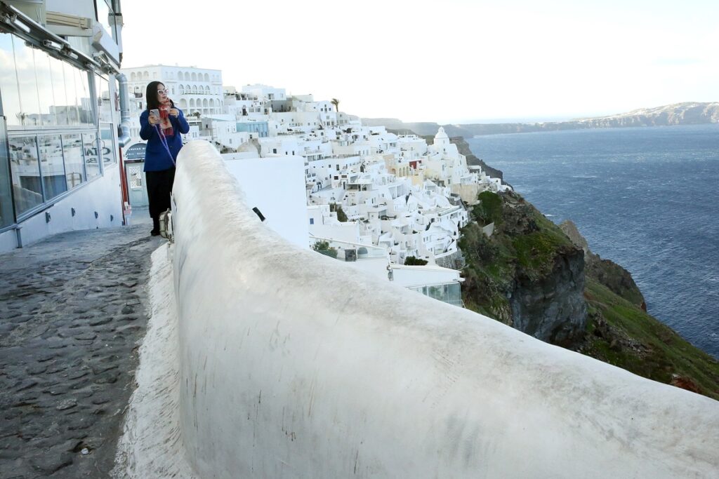 Una mujer camina en el pueblo casi evacuado de Fira en la isla de Santorini, Grecia.