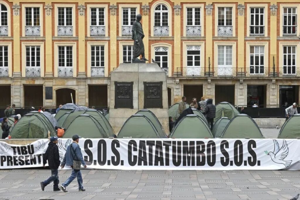 Fotografía de archivo que muestra a personas caminando frente a un campamento de líderes campesinos de la región del Catatumbo, en la Plaza de Bolívar en Bogotá (Colombia).