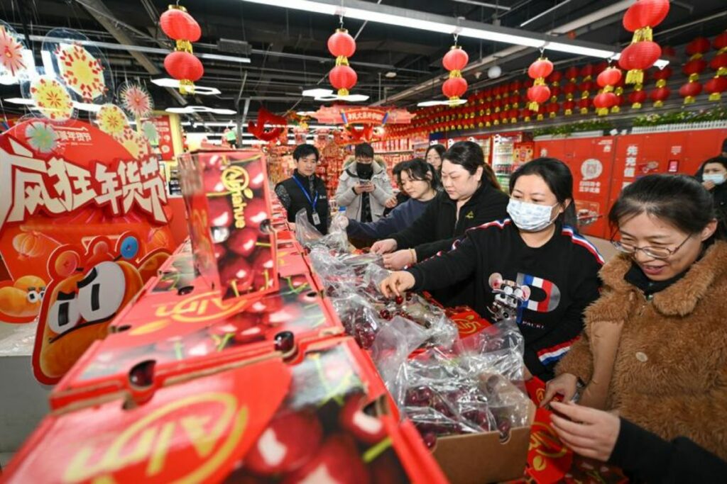 Clientes seleccionan cerezas chilenas recién llegadas a un supermercado, en Tianjin, en el norte de China, el 26 de diciembre de 2024.