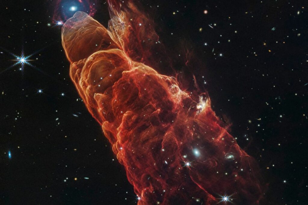 La gran capacidad de observación y resolución de imagen del telescopio espacial James Webb ha revelado los detalles de la alineación fortuita y aleatoria de un chorro protoestelar y una galaxia espiral distante.