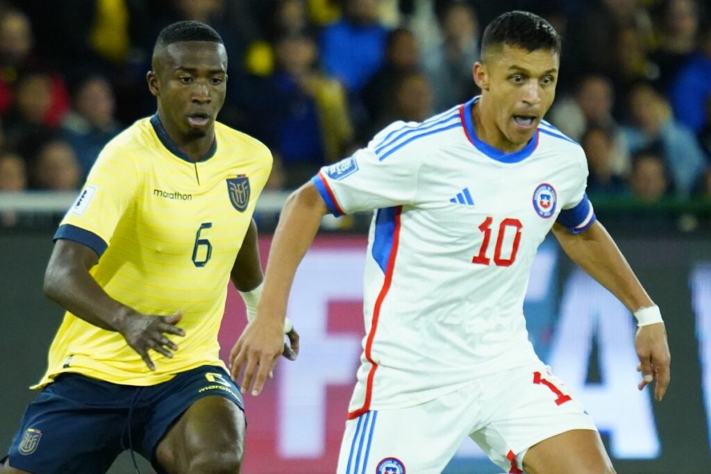 Willian Pacho (izq.) persigue a Alexis Sánchez en el partido de ida de eliminatorias de las Selección de Ecuador ante Chile.