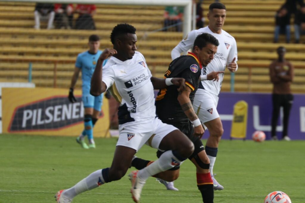 Leonel Quiñónez (izq.) de Liga de Quito y Andrés López (der.) del Deportivo Cuenca disputan un balón.