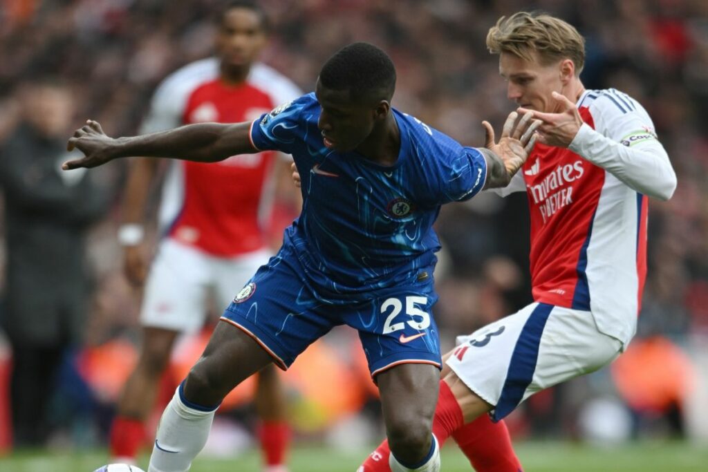 Moisés Caicedo (izq.) del Chelsea disputa un balón con Martín Odeggard del Arsenal.