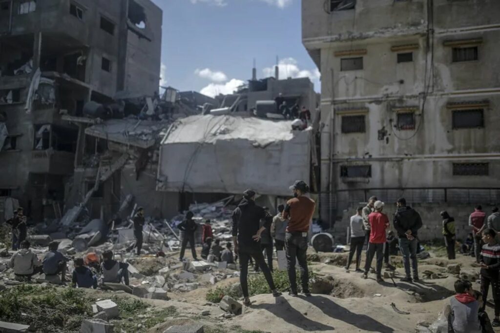 Palestinos buscan cadáveres y supervivientes entre los escombros de una casa destruida tras un ataque aéreo israelí en la ciudad de Gaza este 19 de marzo.