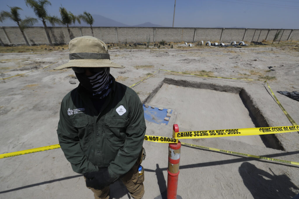Un integrante de la Comisión de Búsqueda de Personas de Jalisco resguarda un área acordonada donde se realizan investigaciones en el Rancho Izaguirre.