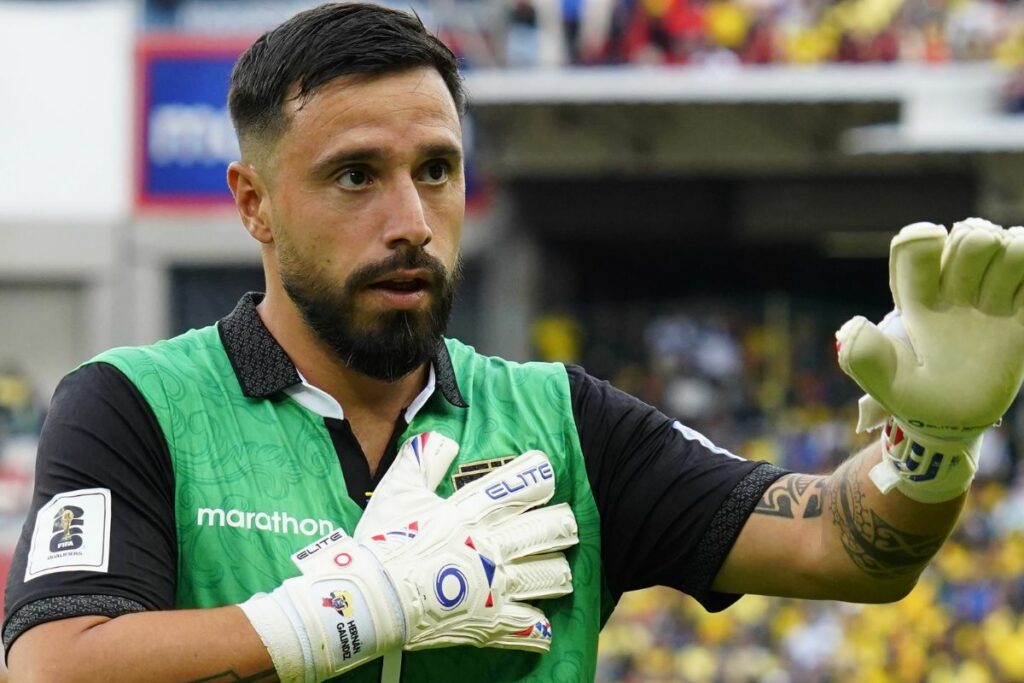 Hernán Galíndez tocando el escudo de la Selección de Ecuador.