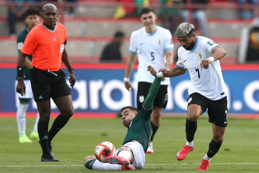 Robson Matheus (i) de Bolivia disputa un balón con Rodrigo Aguirre de Uruguay este martes 25 de marzo de 2025, en un partido de las eliminatorias sudamericanas para el Mundial de 2026 en el estadio Municipal de El Alto.