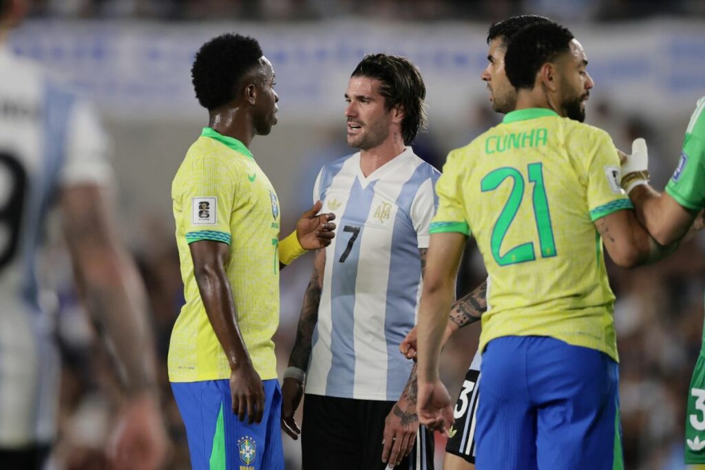 Rodrigo De Paul (c) de Argentina habla con Vinícius Júnior (i) de Brasil.