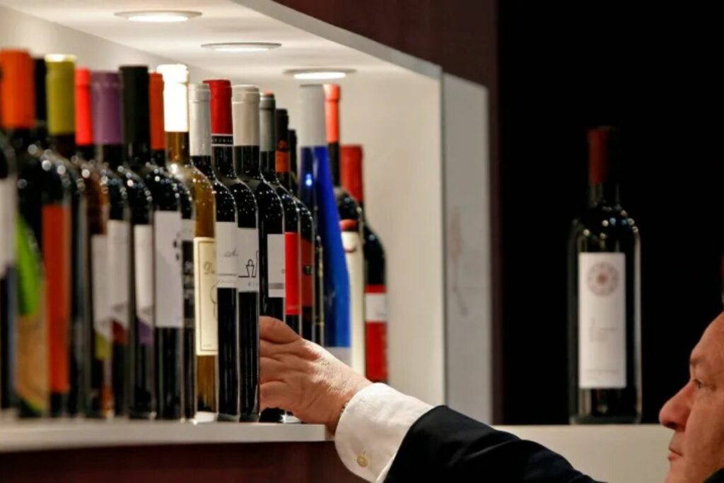 Un hombre observa vinos valencianos en una muestra.