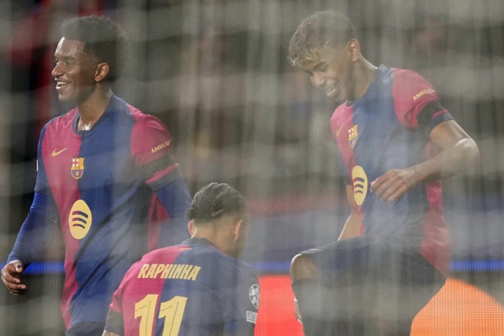 El delantero del Barcelona Lamine Yamal (d) celebra su gol contra el Benfica con el centrocampista brasileño Raphinha, durante el partido de vuelta de octavos de final de la Champions League.