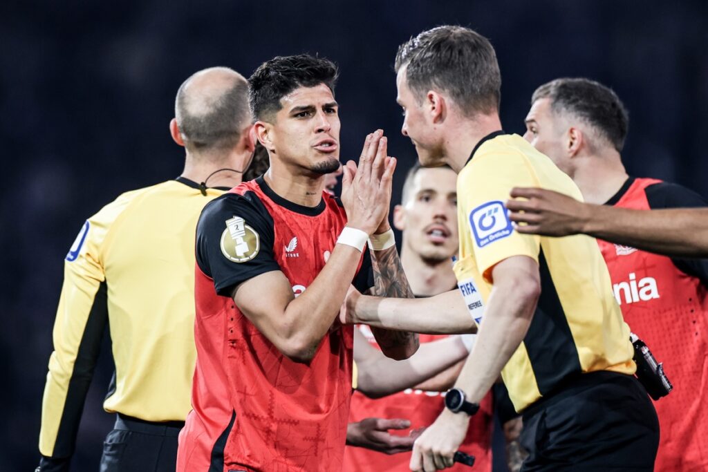 Piero Hincapié del Bayer Leverkusen conversa con el árbitro tras recibir tarjeta amarilla ante el Arminia Bielefelf en la Copa de Alemania.