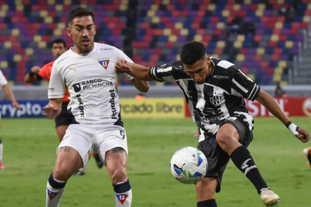 Lisandro Alzugaray (izq.) de Liga de Quito disputa un balón con un rival en la Copa Libertadores.