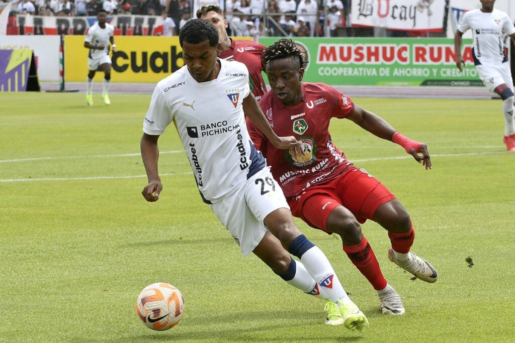 Bryan Ramírez de Liga de Quito protege un balón contra Glendys Mina de Mushuc Runa.