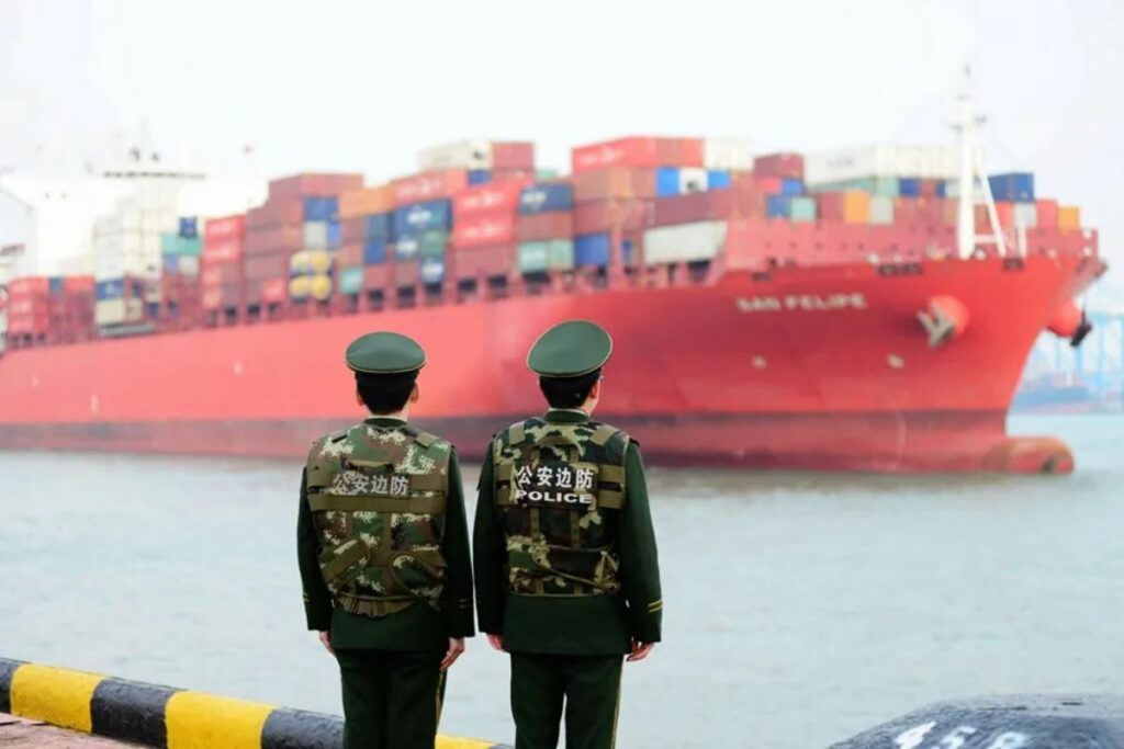 Dos guardias fronterizos mientras hacen guardia en un puerto en Qingdao (China).