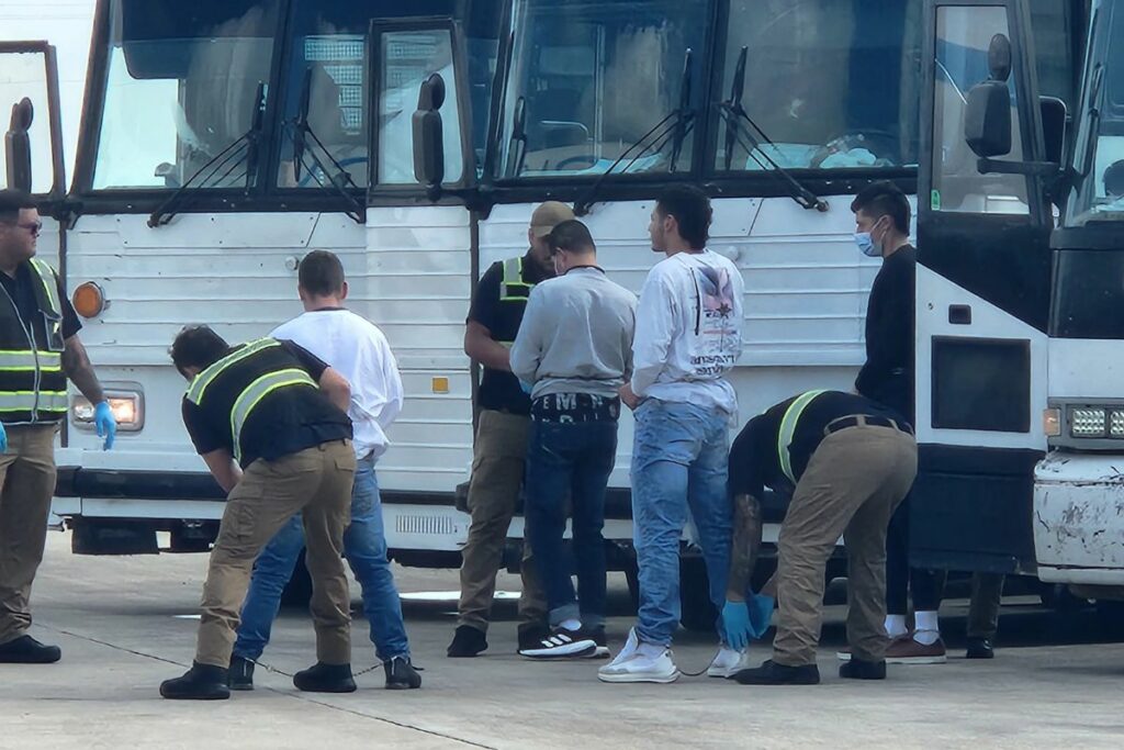 Oficiales de migración requisan a migrantes antes de ser deportados este jueves en el Aeropuerto de Harlingen, Texas (Estados Unidos).