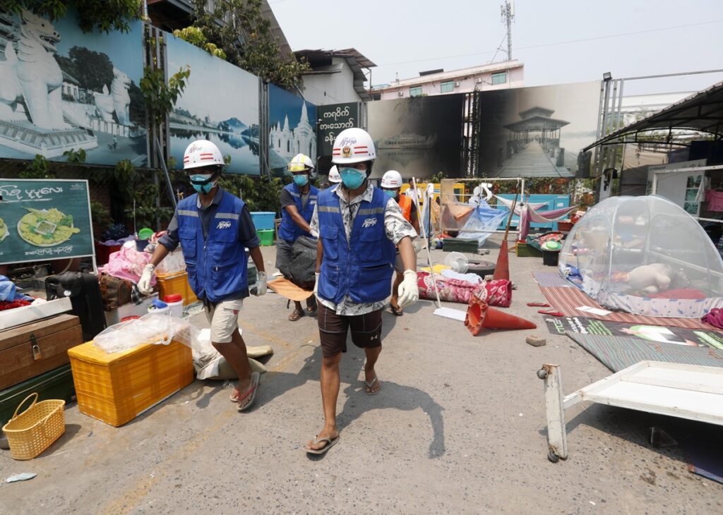 Voluntarios cargan el cuerpo de una víctima del terremoto en Mandalay, Birmania (Myanmar).