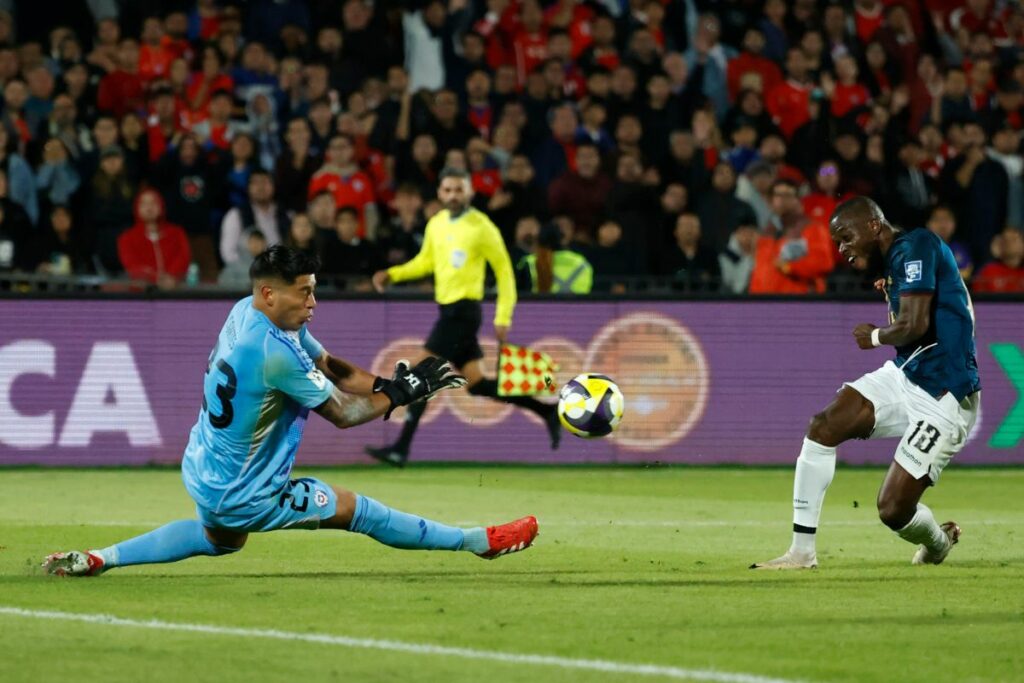 Brayan Cortés (i) de Chile disputa el balón con Enner Valencia en un partido de las eliminatorias sudamericanas para el Mundial de 2026 entre las selecciones de Chile y Ecuador.